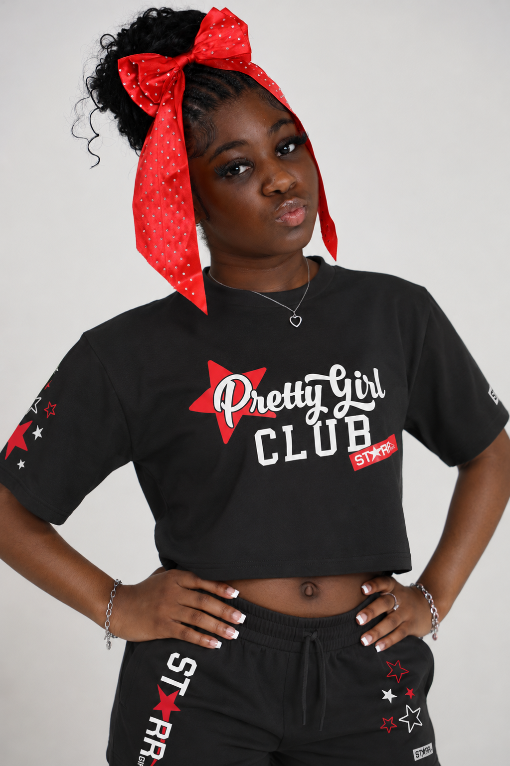 Starr Girls Pretty Girl Club crop top featuring short sleeves in black and red, worn over a white background in a casual lifestyle setting.
