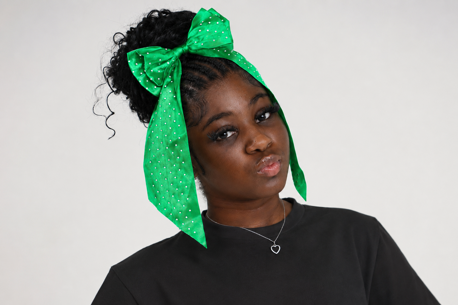 Green bow headband from Starr Girl Pretty Girl Club, featuring a large, vibrant green fabric bow for girls' accessories.